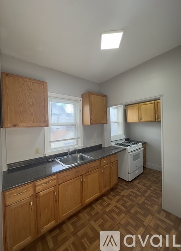 A kitchen with wooden cabinets and a white dishwasher.