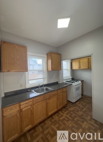 A kitchen with wooden cabinets and a white dishwasher.