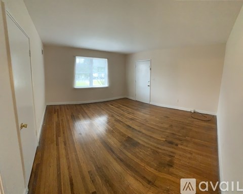 A room with wooden flooring and a window.