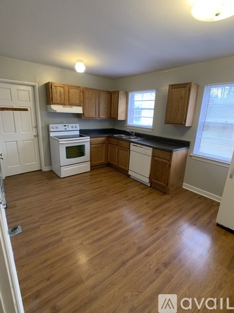 A kitchen with wooden floors and white appliances.