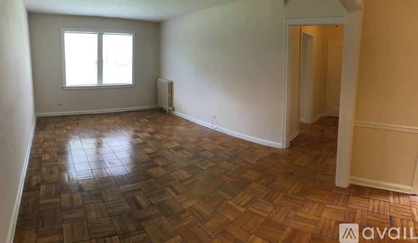 A room with wooden flooring and a window.