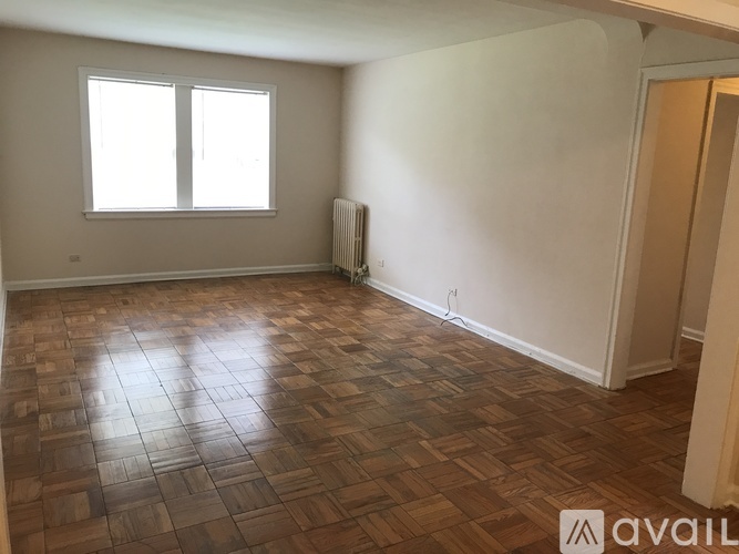 A room with wooden flooring and a window.