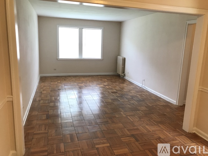 A room with wooden flooring and a window.