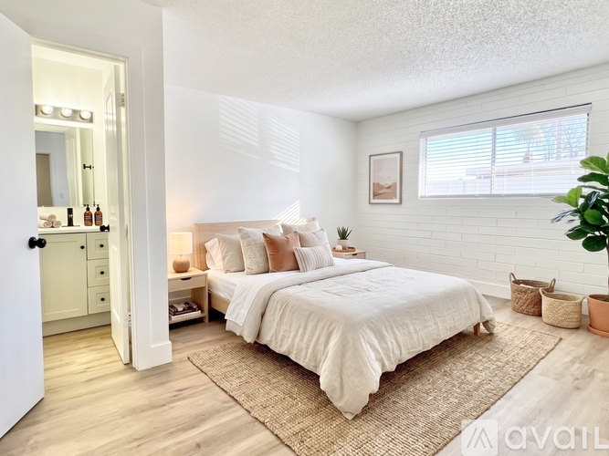 A bedroom with a large bed and a plant.