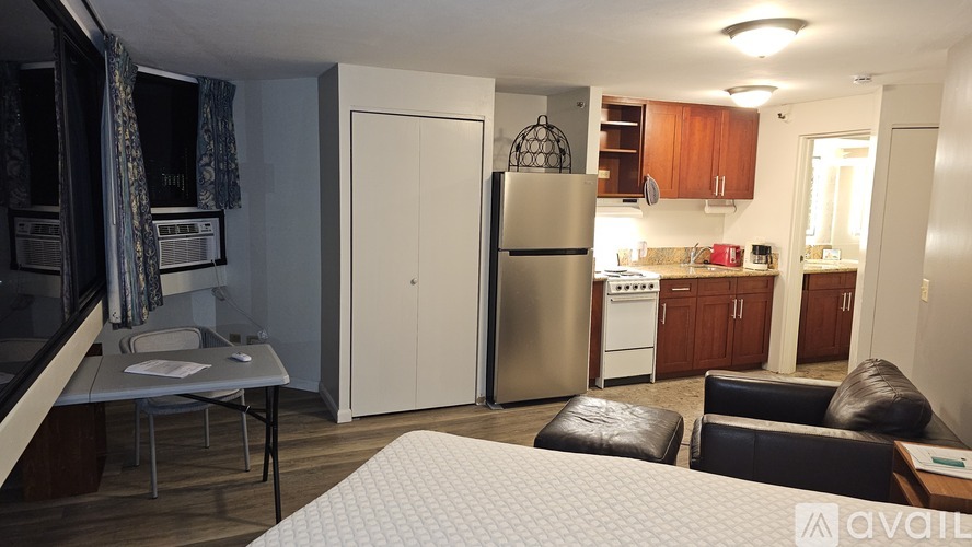 A kitchen with a refrigerator, stove, and cabinets.