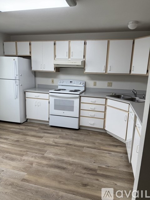 A kitchen with white appliances and cabinets.