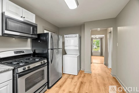 A kitchen with black and white appliances and wooden floors.