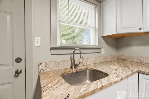 A kitchen with a marble countertop and a window.