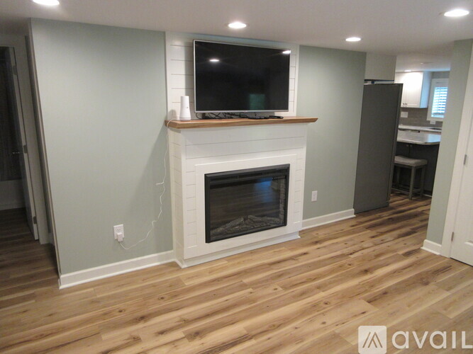 A modern living room with a fireplace and a flat screen TV mounted above it.