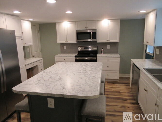 A kitchen with a marble countertop and stainless steel appliances.