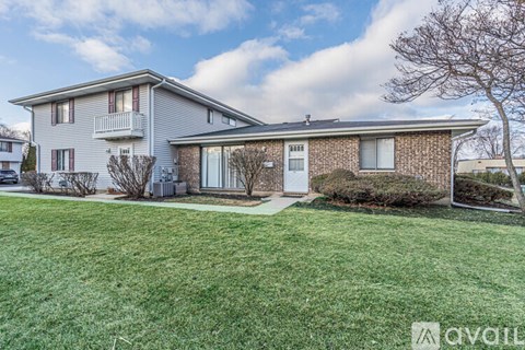 A house with a lawn in front and a tree to the right.