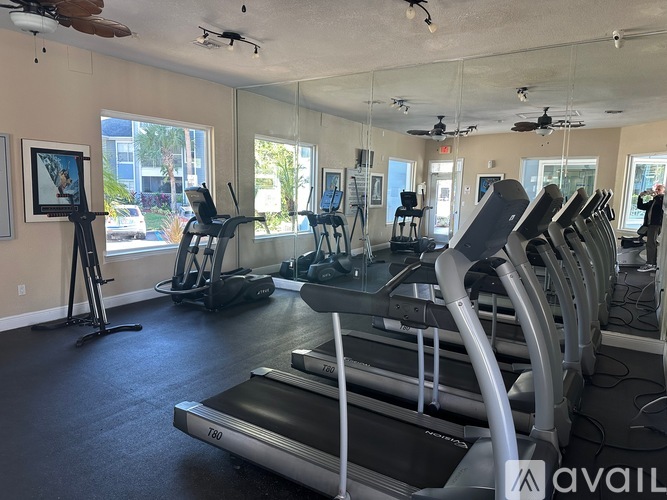 A gym with treadmills, elliptical machines, and other exercise equipment.