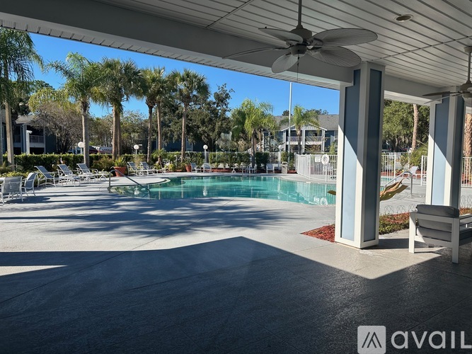A pool area with a ceiling fan and a bench.