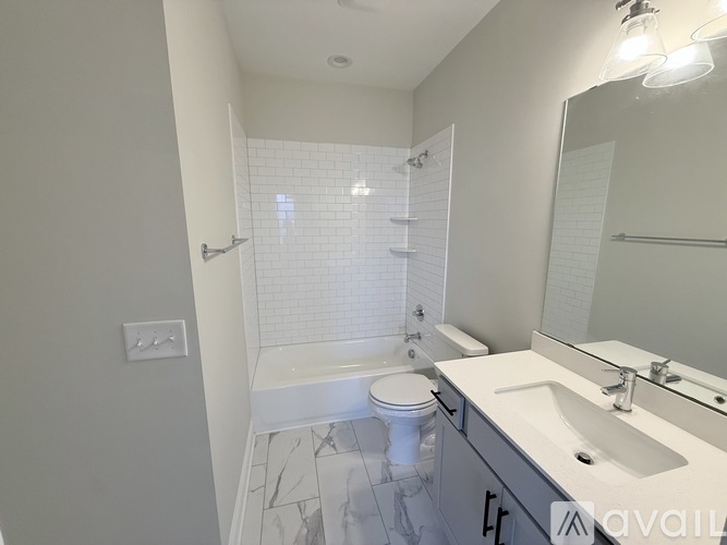 A white bathroom with a toilet, sink, and shower.