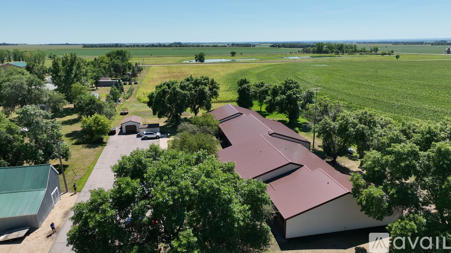 A farm with a red roofed building and a green field.