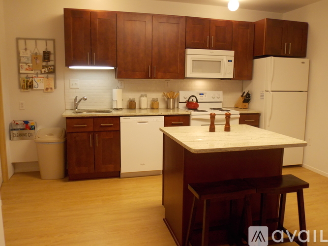 A kitchen with brown cabinets and white appliances.