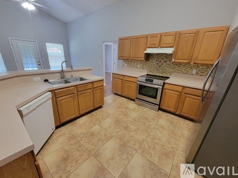 A kitchen with wooden cabinets and a tiled floor.