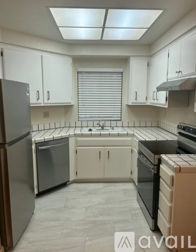 A kitchen with white cabinets and stainless steel appliances.