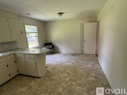 A kitchen with beige cabinets and a tiled floor.