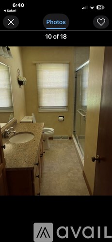 A bathroom with a toilet, sink, and mirror.