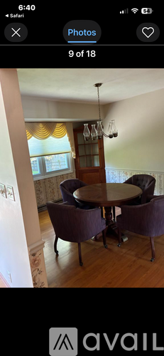 A dining room with a round table and chairs.