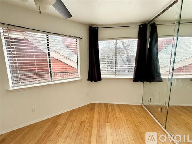 A room with a window and a wooden floor.