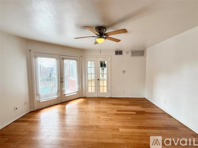 A room with wooden floors and a ceiling fan.