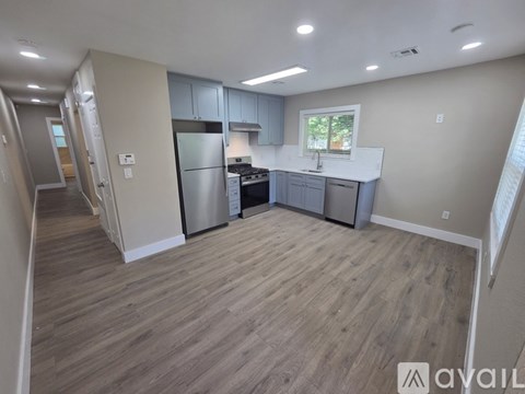 A kitchen with a refrigerator, stove, and sink.