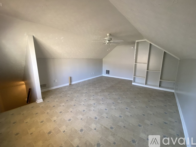 A spacious room with a ceiling fan and tile flooring.