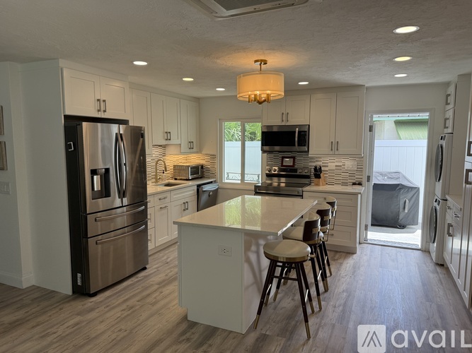 A modern kitchen with stainless steel appliances and a central island.