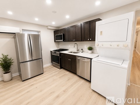A kitchen with a refrigerator, oven, and microwave.