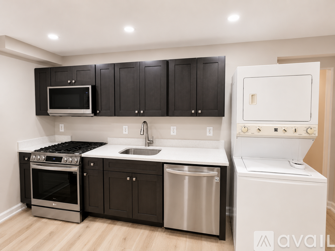 A kitchen with black cabinets and stainless steel appliances.