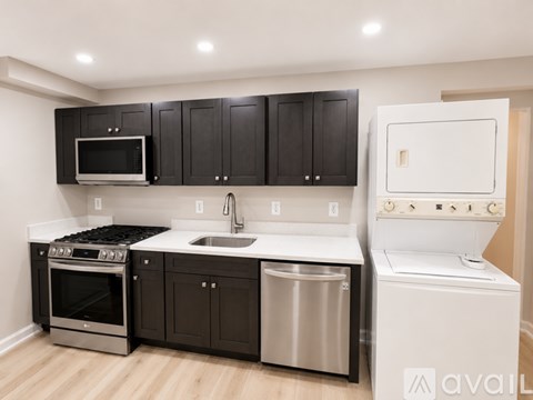 A kitchen with black cabinets and stainless steel appliances.