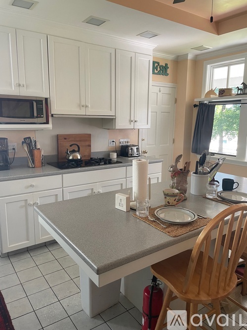 A kitchen with a table and chairs.