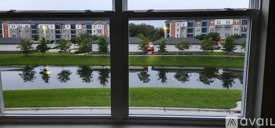 A view of a lake through a window with buildings in the background.