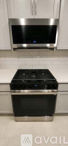 A stainless steel microwave above a stove in a kitchen.