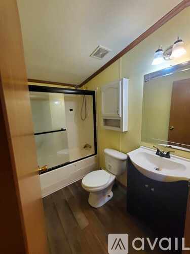A bathroom with a toilet, sink, and mirror.