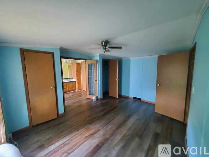 A room with wooden floors and a ceiling fan.
