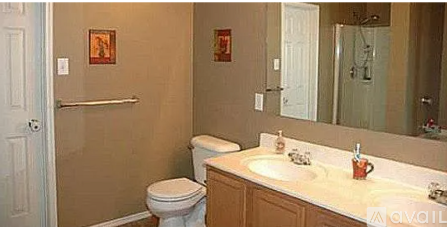 A bathroom with a toilet, sink, and mirror.