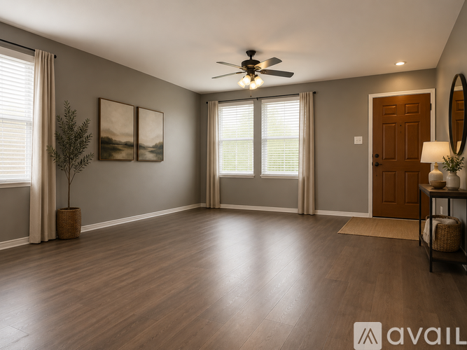 A spacious room with a ceiling fan and a door.