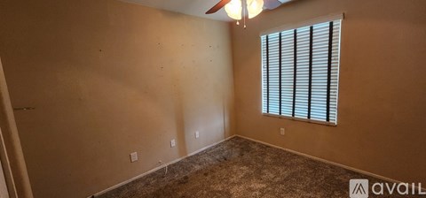 A room with a window and a carpeted floor.