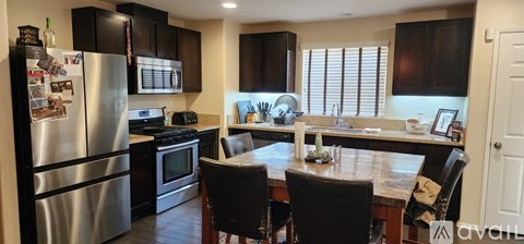 A kitchen with a table and chairs.