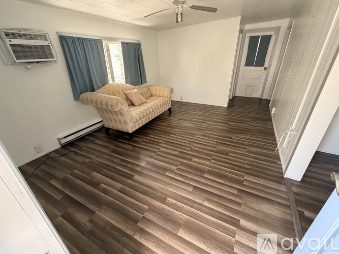 A living room with a couch and a ceiling fan.