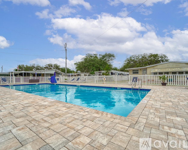 A large outdoor swimming pool surrounded by a tiled patio.