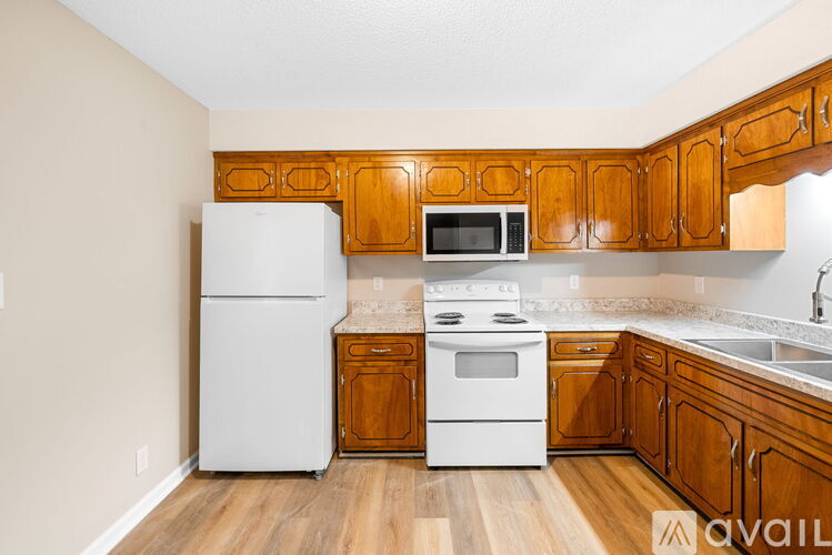 A kitchen with wooden cabinets and white appliances.