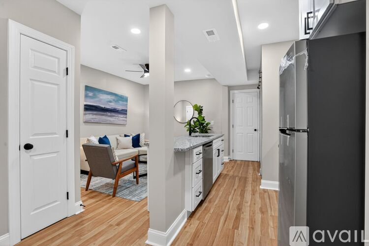 A modern kitchen with a refrigerator on the right and a dining area with a table and chairs in the middle.