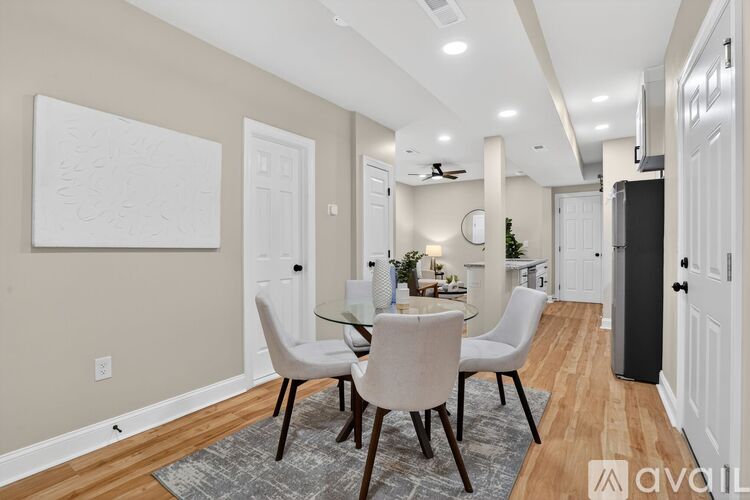 A dining room with a table set for two and a television in the corner.