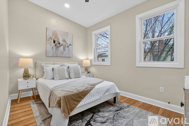 A bedroom with a large bed and a painting on the wall.