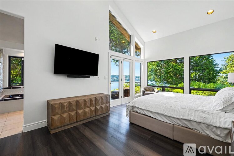 A bedroom with a large bed and a flat screen TV mounted on the wall.