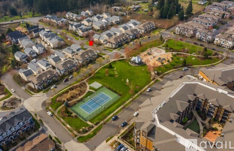 A bird's eye view of a residential area with a tennis court and a swimming pool.